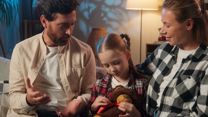 Happy European family at evening home talking parents hugging daughter talk conversation smiling relaxing on couch satisfied parents with child girl kid holding toy teddy bear adopt custody cozy rest