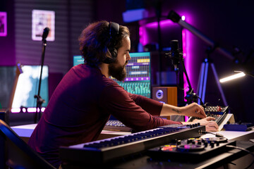 Musical producer working on artistic post production with editing and synchronizing recorded songs....