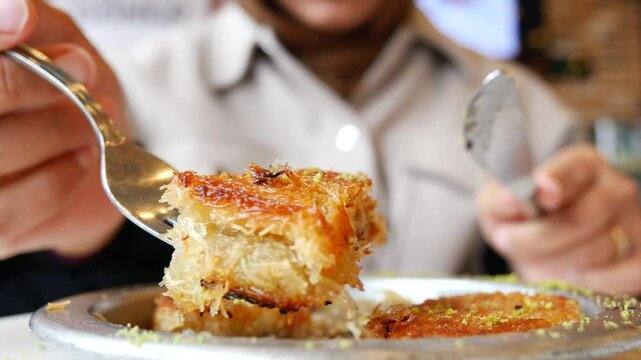woman enjoying Turkish dessert kunefe