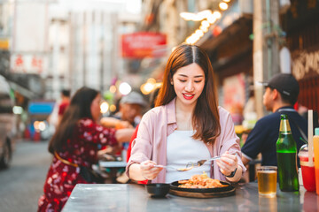 Traveler woman enjoy eating street food spicy thai tasty menu travel at chinatown Yaowarat,...