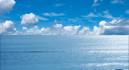 青い空と輝く海　青空に浮かぶ夏の積雲　風に流れる雲の風景　キラキラ輝く波の背景　夏休み・アウトドア・観光・旅行・行楽・バカンスのイメージ