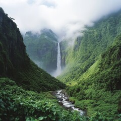 Obraz premium Majestic Waterfall Cascading Down Lush Mountain Valley Landscape