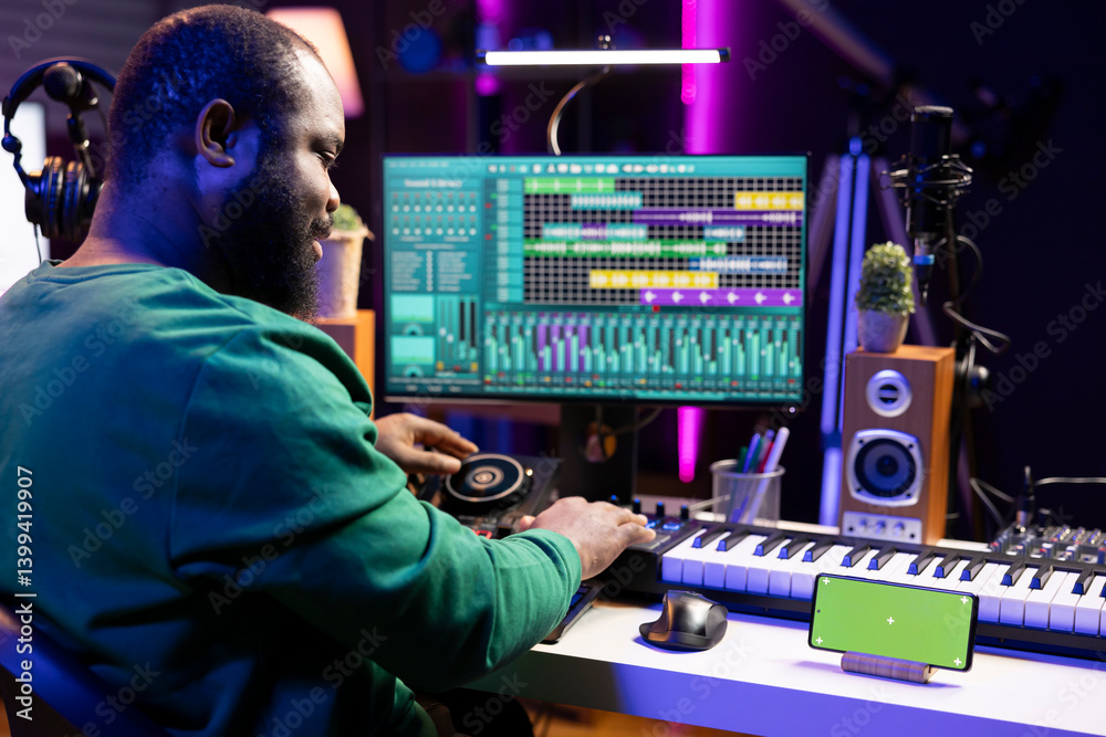 Leinwandbilder Male composer using mixing console and piano to edit tracks, having a greenscreen on smartphone. Musician producing new songs with mixing and mastering techniques in home studio.