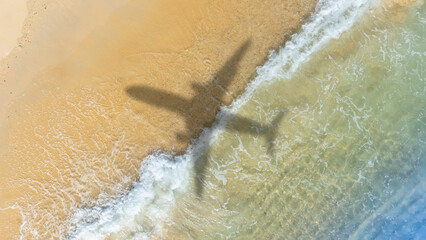 Aerial view of shadow passenger plane silhouette and sandy beach blue sea with waves at sea beach summer vacation sea travel concept	