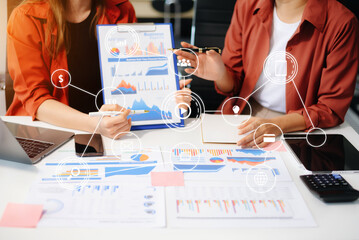 Two young business women sitting at table.colleagues working together, have a discussion and using...