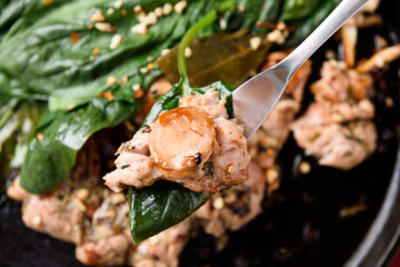 A view of vegetables and chicken being lifted
