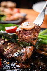 A view of vegetables and steak being lifted
