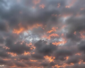 Fototapeta premium A dramatic sky filled with gray clouds, illuminated by vibrant orange and red hues at sunset, creating a captivating and moody atmosphere.