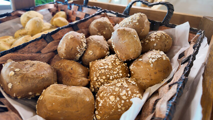Freshly baked whole grain rolls in a rustic basket display