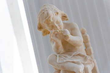 a marble stone statue of a child playing, vintage art style with history, yellow marble under sunlight, white background