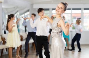 Three pairs of teen boys and girls rehearse group performance and dance incendiary twist dance...