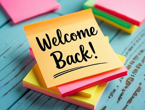 Vibrant post-it note with welcome back handwriting placed on colorful notes, conveying greeting, motivation, and organization in a cheerful work or school environment