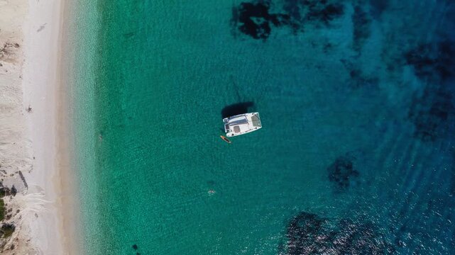 Top down drone shot of a Catamaran moored to Filiatro Beach, Ithaca Island, Greece