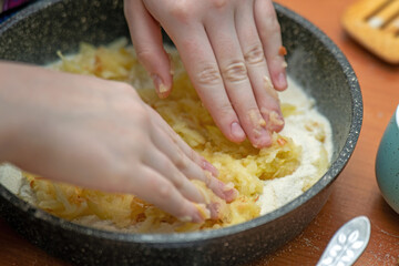 Spreading mashed apple filling onto a flour base in a skillet for rustic raw apple pie preparation
