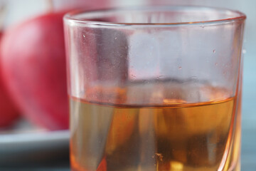 Delicious apple juice served in a clear glass with fresh apples nearby
