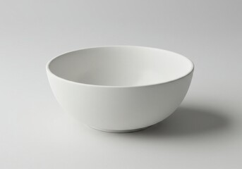 A simple white bowl is centered on a plain background casting a soft shadow to the right side of it