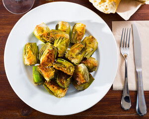 Plate of tasty roasted in oil organic artichokes