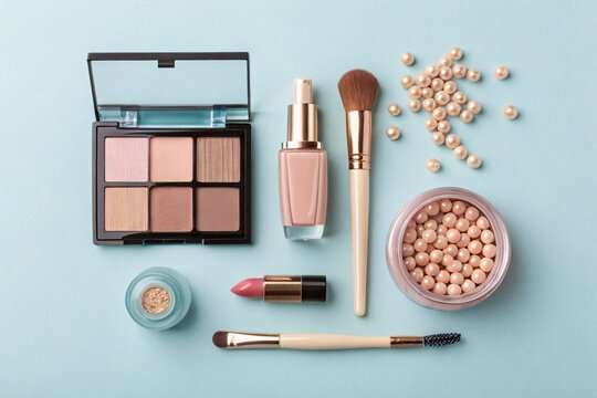 Cosmetics flat lay with eyeshadow foundation brush and lipstick on blue background