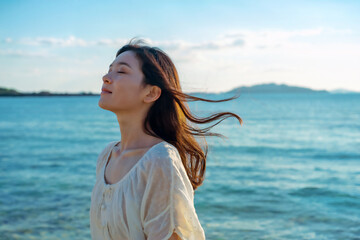 Obraz premium 長い髪が海風になびく日本人女性 Generative AI 