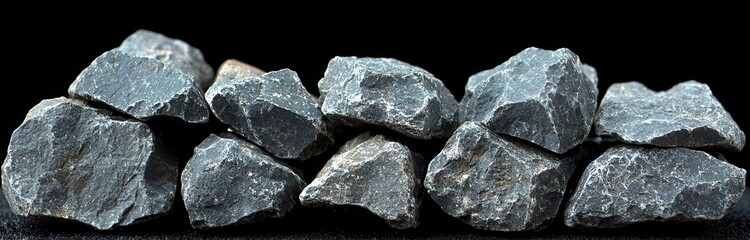 Fototapeta premium A pile of natural rocks displaying unique textures and colors against a black background, perfect for earth-related themes.