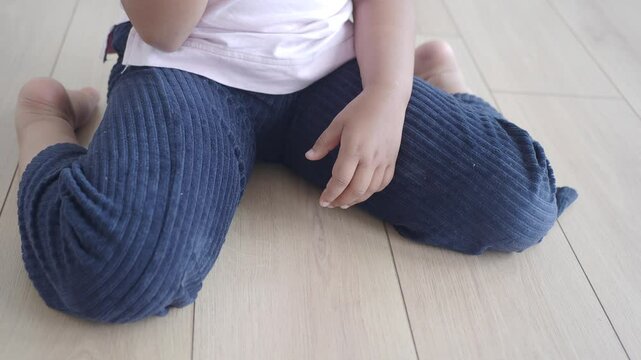 chid sitting on w shape on floor 