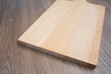 wooden patterned chopping board, square shaped, on a wooden patterned background,