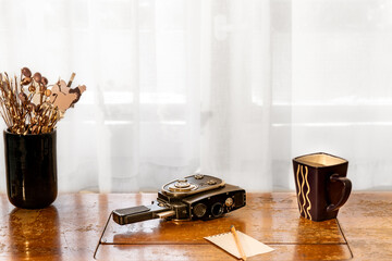Vintage Camera and Mug Arranged on Wooden Table by Window
