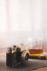 Vintage Camera Next to Whiskey Glass and Cigar on Table