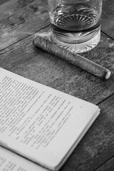 Black And White Still Life Featuring Book, Cigar, And Glass On Wooden Table