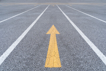 Disruptive ideas in business. Bold yellow arrow challenging the status quo on asphalt road.
