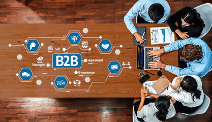 A vibrant team engages around a modern office table, discussing B2B strategies with technology...