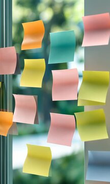 A window with colorful sticky notes on it. The notes are in different colors and shapes, and they are scattered all over the window