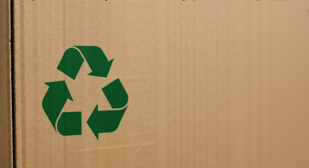 Green recycling symbol on cardboard box. Sustainable packaging concept ideal for environmental awareness and waste management education
