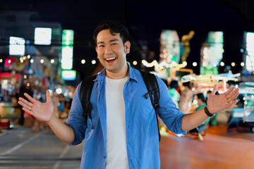 Portrait of a young Asain man standing in the night market street.