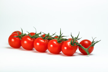 Cherry tomatoes on a branch on a white background