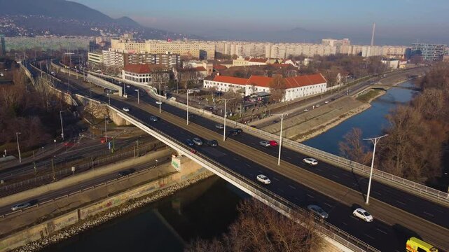 Top-down drone overview of Budapest streets and rooftops with long shadows in golden sunlight