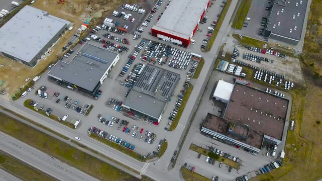 Aerial drone footage view of manufacturing warehouses and buildings in Laagri Estonia near Tallinn P&auml;rnu highway during a cloudy spring or autumn day. Cars, vehicles and trucks drive on the road below
