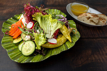 Colorful vegan salad with radish, cucumber, lettuce, and hummus.