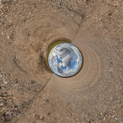 blue hole sphere or globe little planet inside grass or sand or dry ground frame background with...
