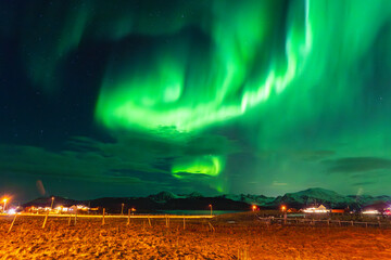 Beautiful Equinox Aurora Borealis over the island of Hillesøya, dancing northern lights with clear colored rays of light, green light in the sky with red and purple strikes! amazing joy in Norway