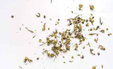 Dried cannabis seeds and leaves. A scattered mix on white background. Suitable for use in content related to botany, herbal medicine, cultivation or alternative health practices.