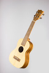 Ukulele on a white background. A guitar made of light wood on a white background. close-up. isolated