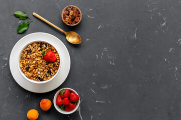 Bowl with oatmeal granola and ingredients - apricots and strawberry. Top view