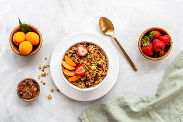 Bowl of cereal granola with strawberry and honey for breakfast, top view
