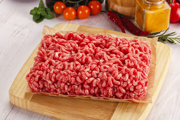 Raw minced beef meat over board
