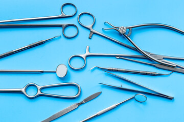 Professional medical equipment - surgery stainless metal instruments on blue background. Medical hand tools