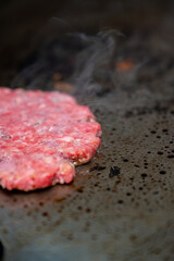 Gros plan sur un steak juteux en pleine cuisson sur une plancha professionnelle, révélant sa texture savoureuse.