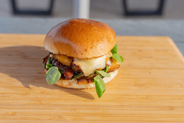 Gros plan sur un hamburger fait maison avec du fromage fondant, un steak et de la salade, le tout...