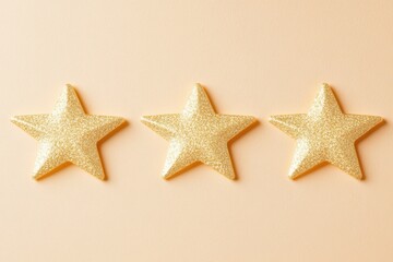 Three golden glitter stars aligned on a soft peach background creating a celebratory and festive mood perfect for awards and recognition