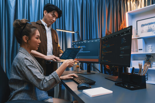 Serious of IT developers discussing intelligent website development coder system running data online two screens with laptop showing information network at neon light room at modern office. Infobahn.